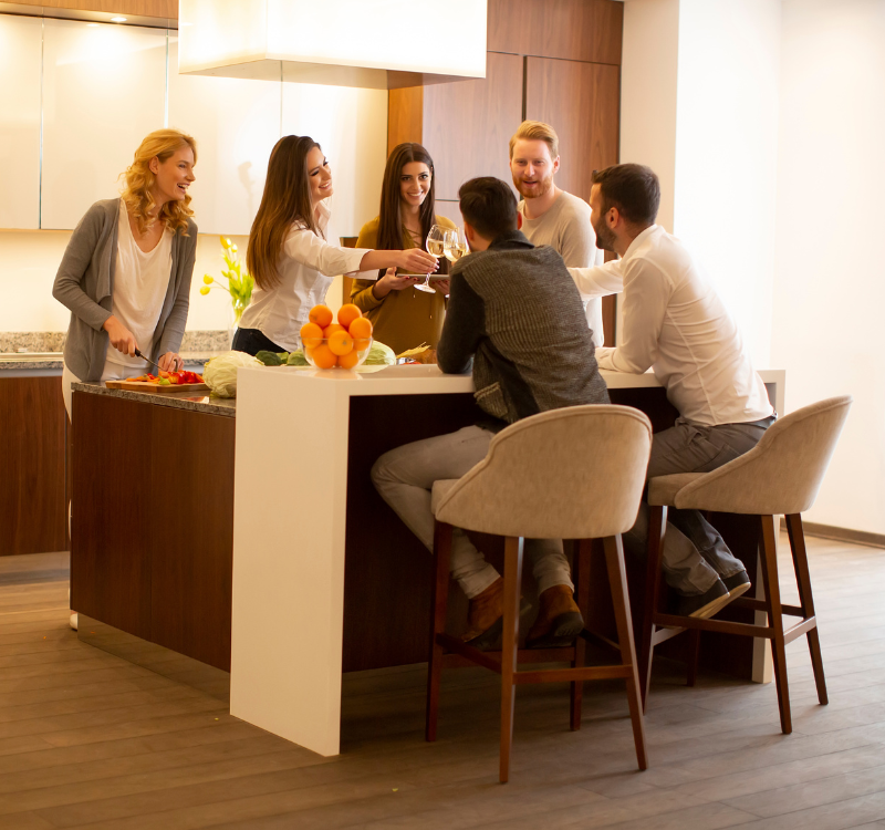 Young professionals enjoying a meal and drinks in a modern kitchen of a Bellevue Corporate Housing unit